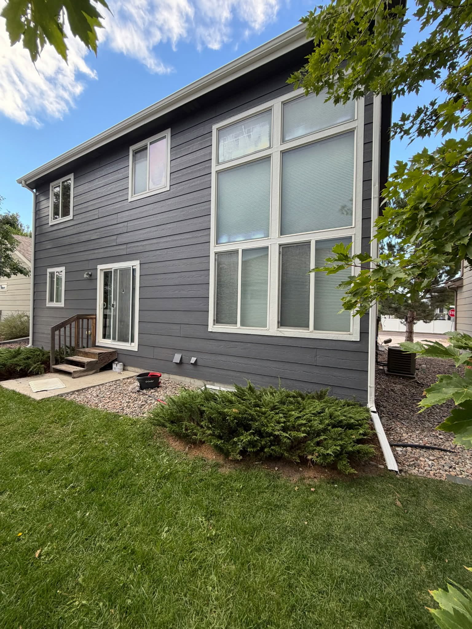 Navy home with large window arrangement — Chess Remodels exterior repaint back elevation